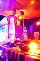 A desk at the WIP.bar at night. We can see a club mate bubble, several lights and 