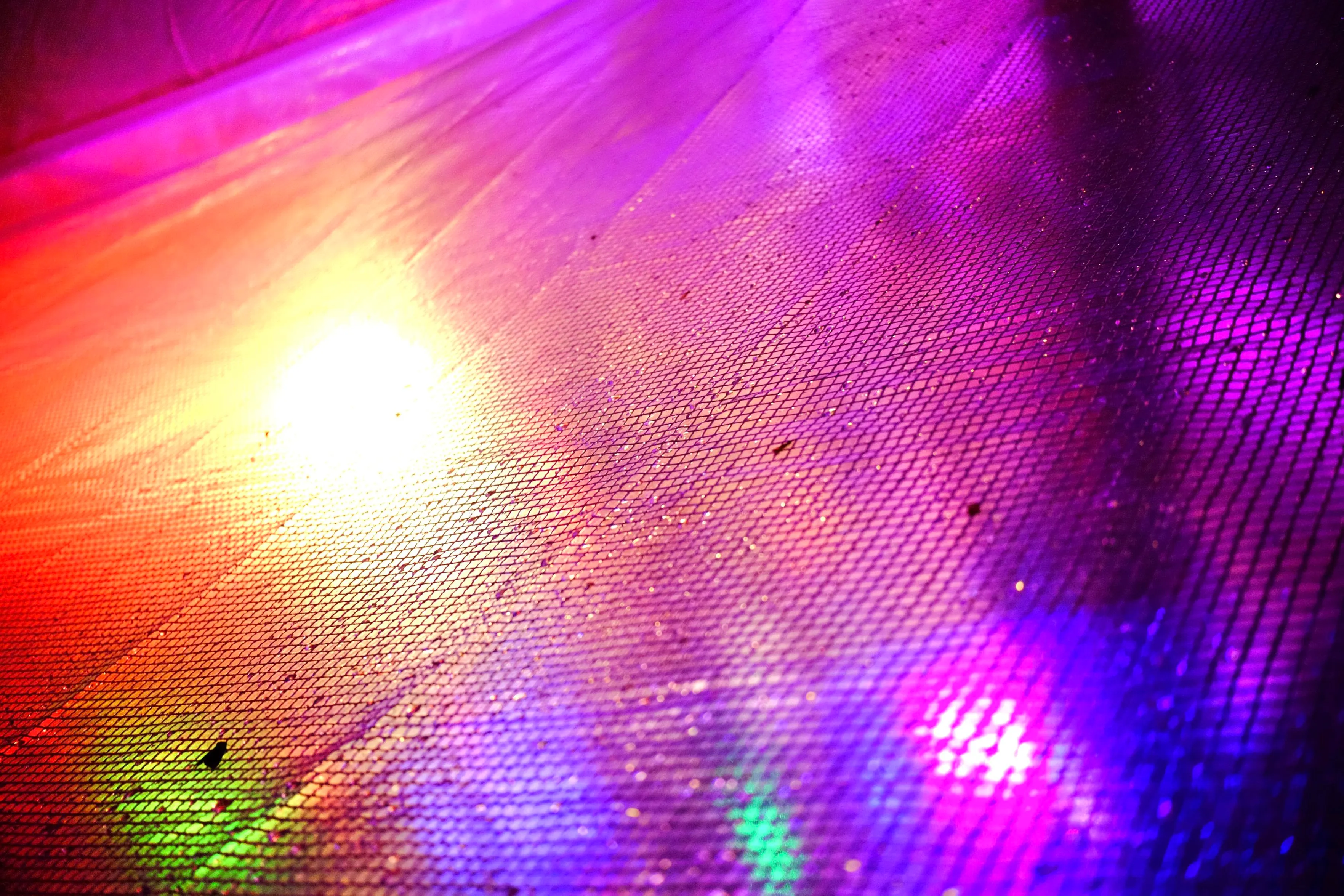 We can see a smallish grid of square-like cells illuminated and reflecting in various colors and gradients.
Speculation says this could be the tarp above the DJ desk near the bar.